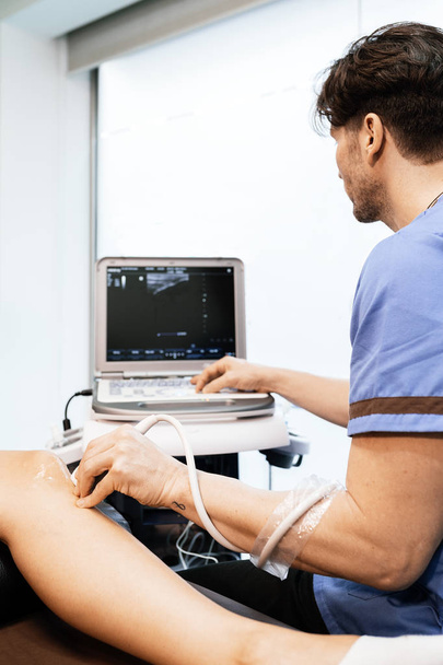 Physiotherapist giving knee therapy to a woman - Valokuva, kuva