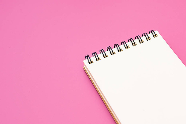 Caderno em branco com espiral para a aplicação de etiquetas em fundo rosa
 - Foto, Imagem