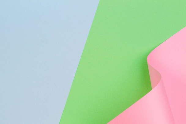Abstract geometrische roze papieren vorm op blauwe en groene kleur papieren achtergrond - Foto, afbeelding