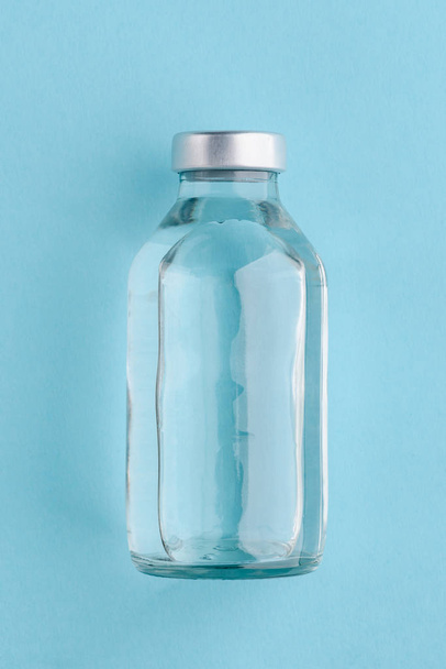 Medical bottle on blue background - Valokuva, kuva