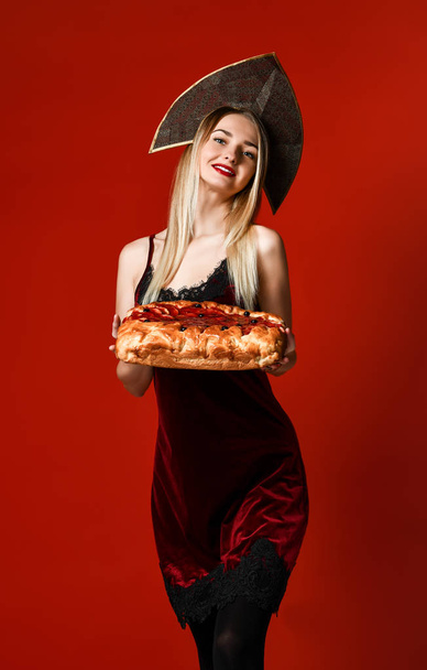 Portrait of a young beautiful blonde holding a delicious homemade cherry pie. - Foto, immagini