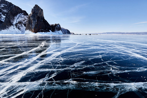 Lake Baikal in winter. Beautiful rocky island on a background of blue sky and smooth ice with cracks  - Foto, Imagem