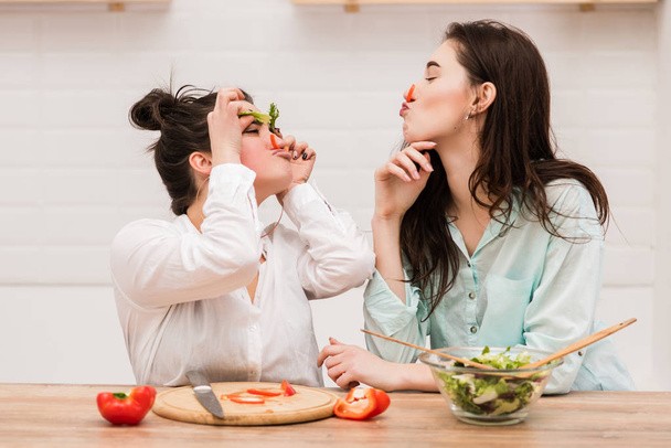 Dwie dziewczyny zabawy z liśćmi sałaty jako brwi - Zdjęcie, obraz