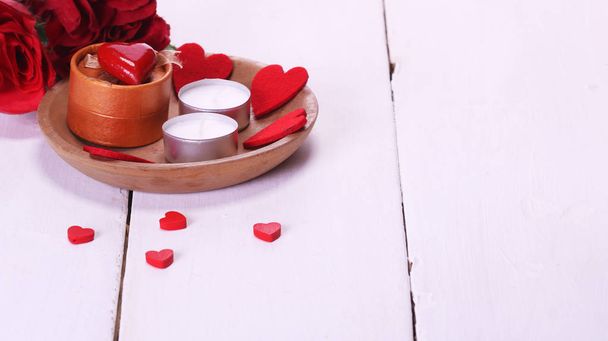 Walentynki z świece, czerwonych róż, biały stół i czerwone serca - Zdjęcie, obraz