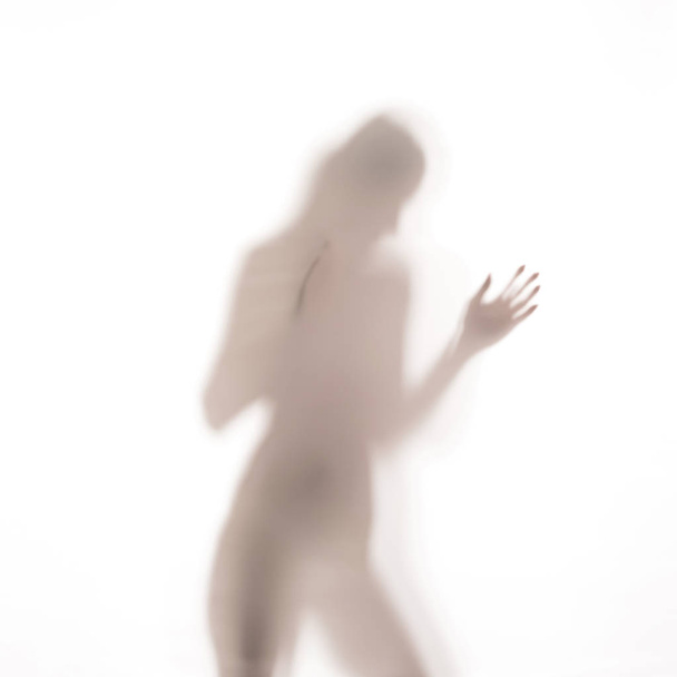 Σιλουέτα γυναίκας που χορεύει πίσω από μια γυάλινη πόρτα - Φωτογραφία, εικόνα