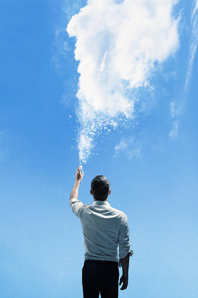 Conceptual picture of a man sprinkling a cloud - 写真・画像