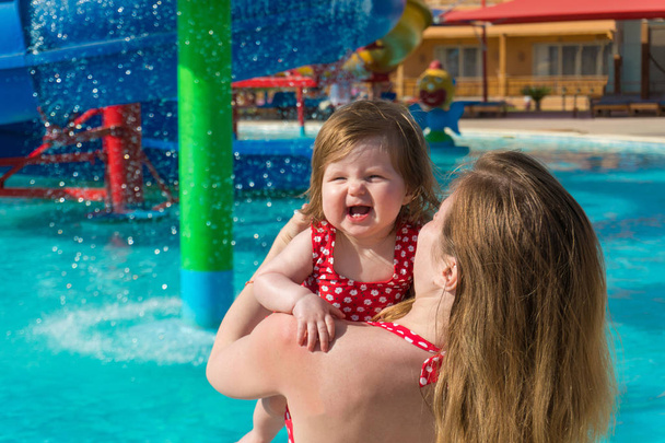 Riendo bebé y madre en parque acuático
 - Foto, Imagen