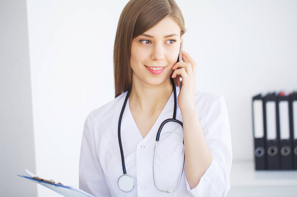 Концепция здоровья. Молодая женщина-врач на фоне современной клиники
 - Фото, изображение