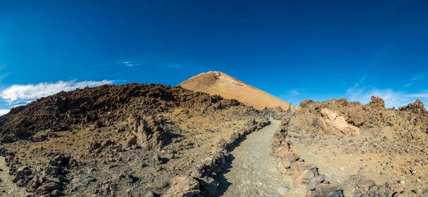 Majestueuze vulkanische kegel stijgt boven spectaculaire lava landschap gevormd. - Foto, afbeelding
