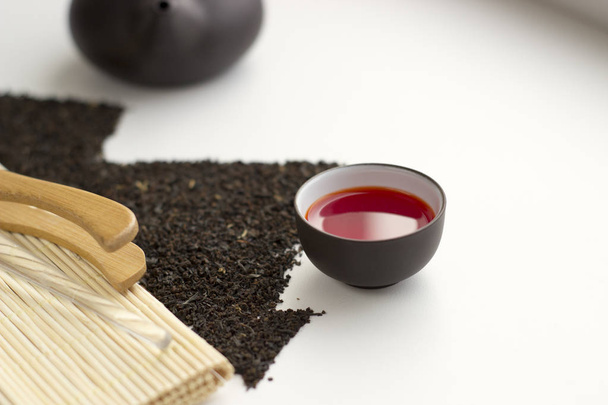 Oolong tea fresh red tea in a cup and black tea scattered in the - Photo, Image