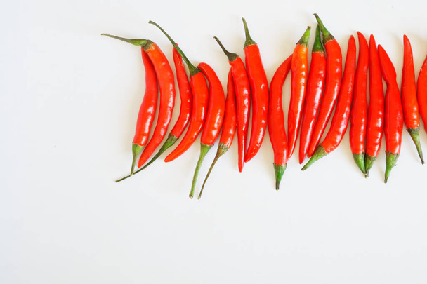 Punaisen chilin paprikat ovat valkoisella puhtaalla pinnalla. Maustaminen ja terveellinen ruoka. Vapaa tila kirjoituksille
. - Valokuva, kuva