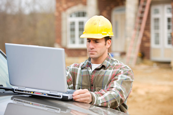 Construction: Worker Uses Wireless Computer - Foto, afbeelding