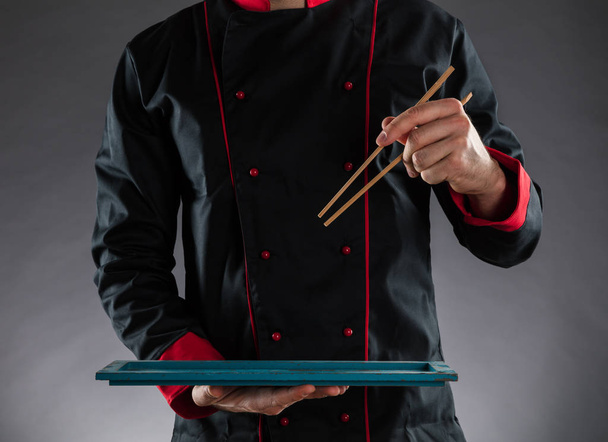 Master chef holding chopsticks and plate - Foto, Bild