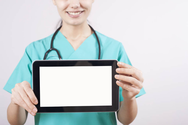 Dokter hand met digitale tablet op grijze achtergrond - Foto, afbeelding