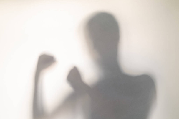 Man in fighting pose behind curtain. - Valokuva, kuva