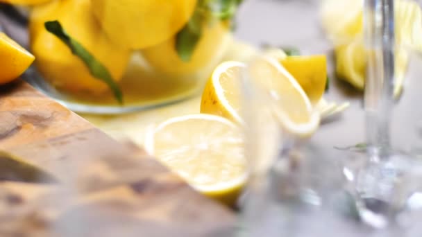 close-up view of glass bowl with fresh ripe lemons and glasses on table, selective focus - Filmmaterial, Video