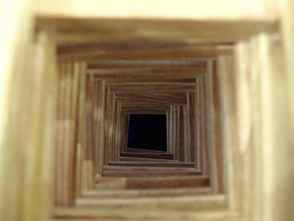 The wooden tunnel to the dark abyss. The concepts of loosing hope, hopeless future, misfortune and mistakes. Selective focus on the bottom. - Photo, Image