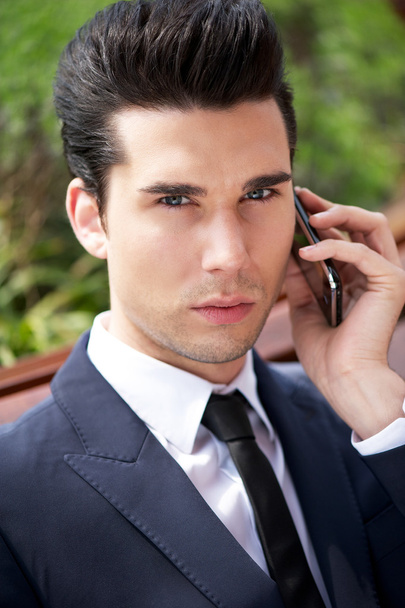 Young businessman talking on phone outside the office - Foto, imagen