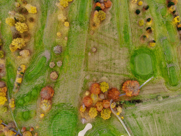 Ilmakuva golfkentälle. Kauniita värikkäitä puita ja vihreä kurssi syksyn / talven aikana Etelä-Belgiassa, Vallonian Brabantissa
. - Valokuva, kuva