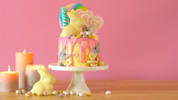Easter candyland drip cake with white chocolate bunny in party table setting. - Footage, Video