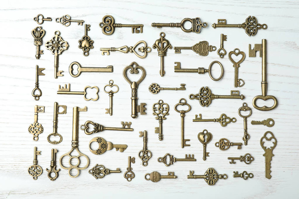 Flat lay composition with old vintage keys on wooden background - Fotó, kép