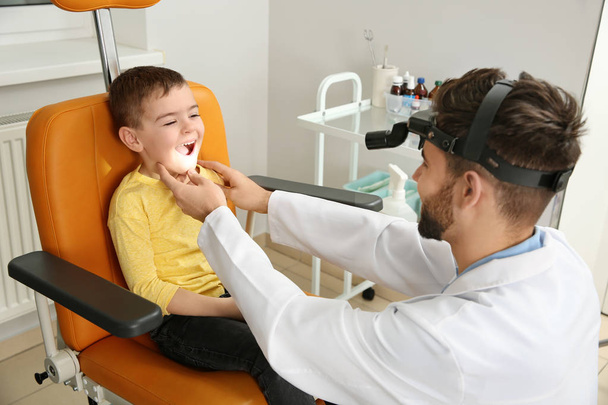 Professional otolaryngologist examining little boy in clinic - Fotó, kép