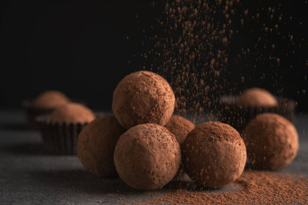 Tasty chocolate truffles powdered with cocoa on table - Фото, изображение