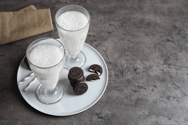 Glasses of milk with chocolate cookies on grey background, space for text - Zdjęcie, obraz