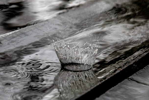 Капля дождя в деревянном полу отскакивая и формируя водяную корону
 - Фото, изображение