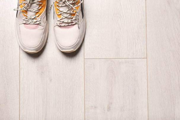 Pair of sport shoes on wooden floor, top view with space for text - 写真・画像