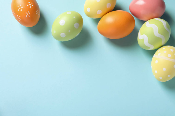Flat lay composition of painted Easter eggs on color background, space for text - Foto, Bild