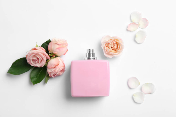 Bottle of perfume and roses on white background, top view - Fotografie, Obrázek