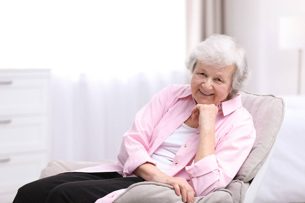 Portrait of beautiful grandmother in living room - Fotografie, Obrázek