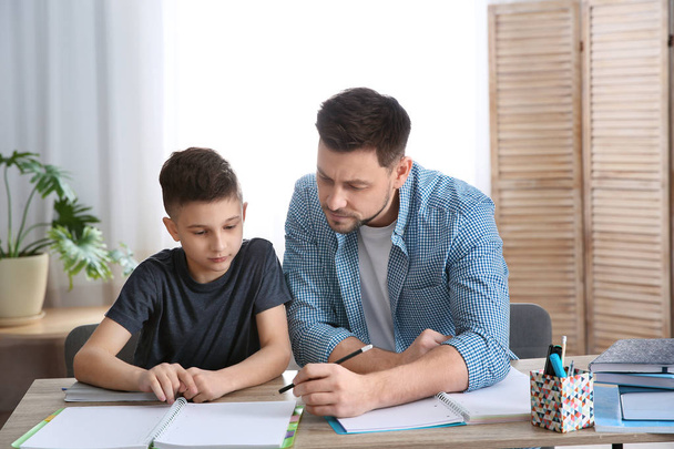 Dad helping his son with homework in room - Foto, Imagen