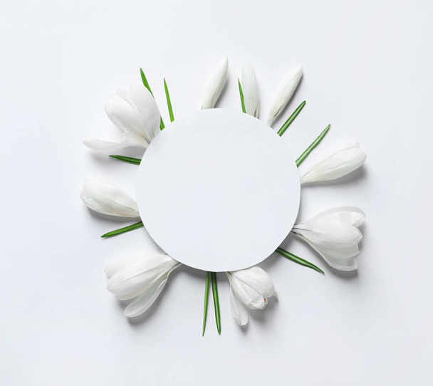 Beautiful spring crocus flowers and card on white background, top view. Space for text - Fotoğraf, Görsel