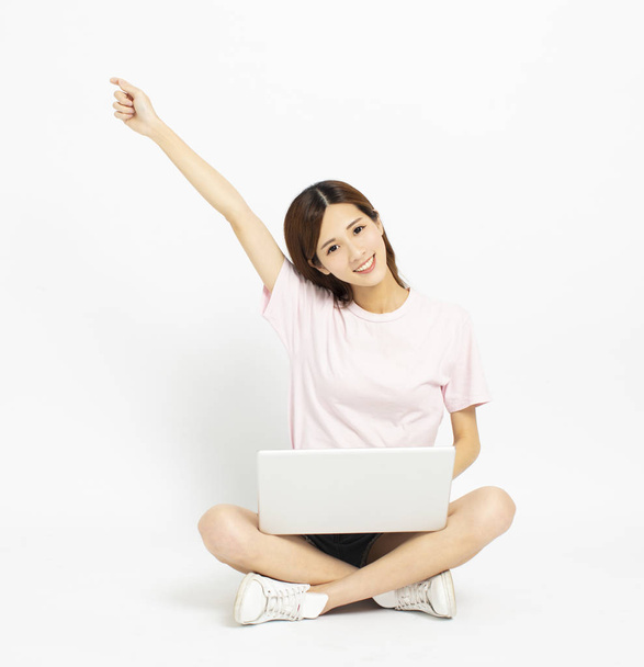 Счастливая молодая женщина, сидящая на полу с ноутбуком
 - Фото, изображение