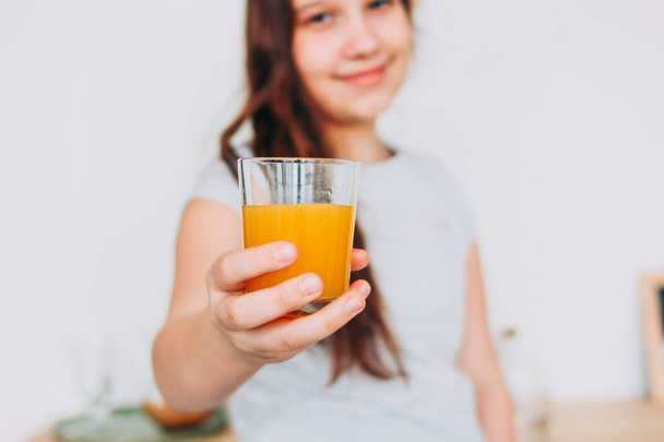 La chica sosteniendo un vaso de jugo de naranja en la mano, enfoque selectivo
 - Foto, Imagen