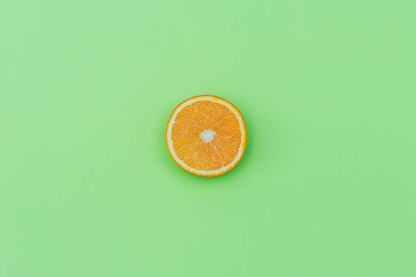 Yeşil arka planda taze turuncu dilimleri renkli bir meyve. Üstteki görünümden - Fotoğraf, Görsel
