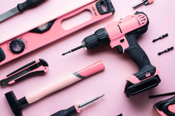 Creative provocation: a flat layout of pink hand tools on a pink background. - Fotó, kép