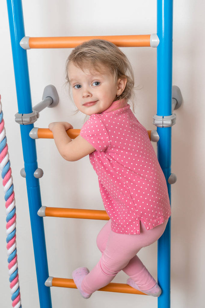 Malá šťastná dívka lezení po žebříku - Fotografie, Obrázek