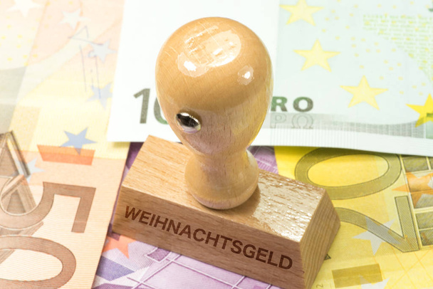 Τραπεζογραμμάτια ευρώ και μια σφραγίδα με το αποτύπωμα του χριστουγεννιάτικου μπόνους - Φωτογραφία, εικόνα