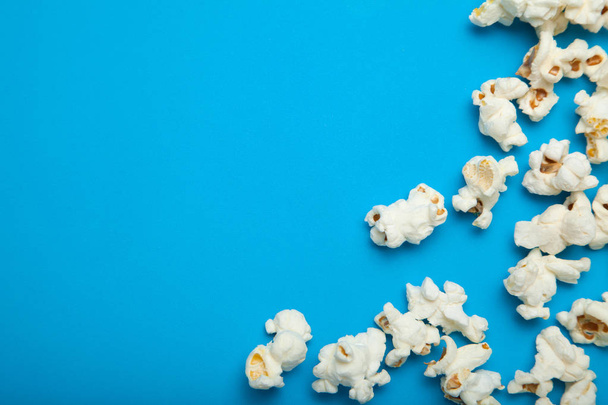Scattered popcorn on a blue background. Copy space. - Foto, Imagen