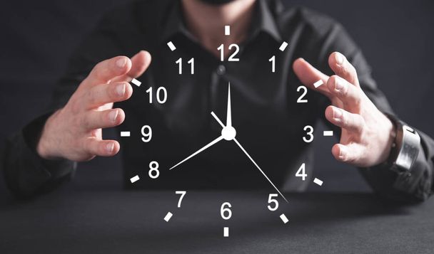 Empresario sosteniendo el reloj. Gestión del tiempo empresarial
. - Foto, Imagen
