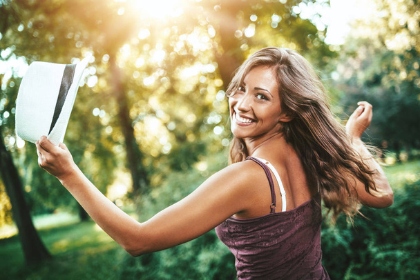 Muotokuva nuori iloinen nainen kävelee vihreässä puistossa
 - Valokuva, kuva