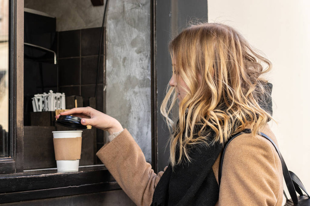 Close up female hand taking paper cup of hot coffee - Valokuva, kuva