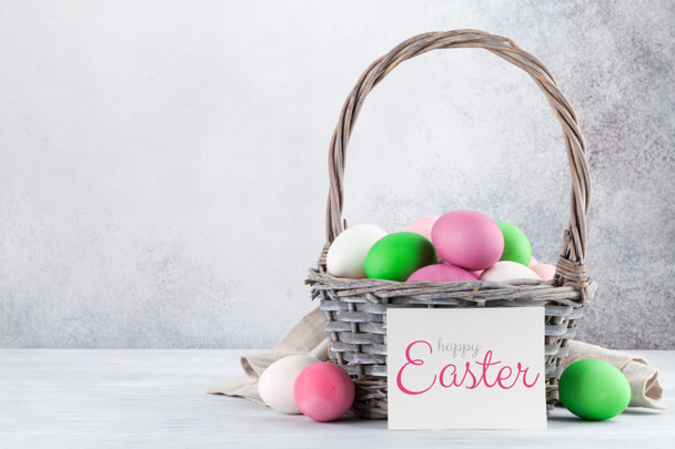 Ευχετήρια κάρτα Πάσχα με πολύχρωμα Πασχαλινά αυγά στο καλάθι - Φωτογραφία, εικόνα