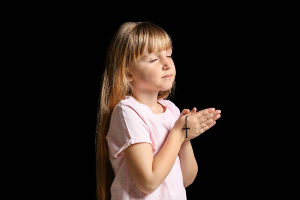 Malá holčička se modlí na tmavém pozadí - Fotografie, Obrázek