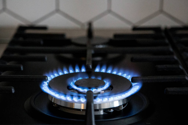 Καυστήρα αερίου σε μαύρη μοντέρνα σόμπα κουζίνας. κουζίνα αερίου χύτρα - Φωτογραφία, εικόνα