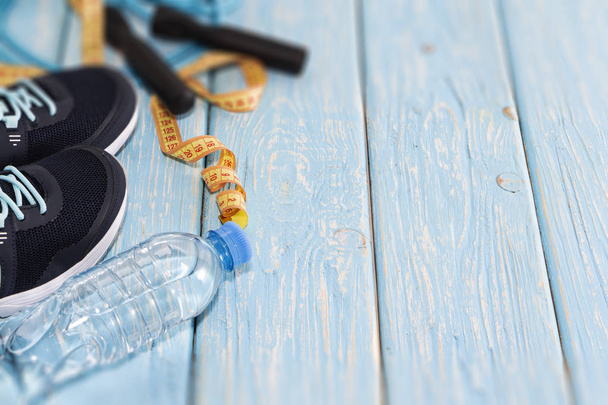 scarpe da ginnastica bottiglia d'acqua, e saltare corda su sfondo di legno azzurro
 - Foto, immagini