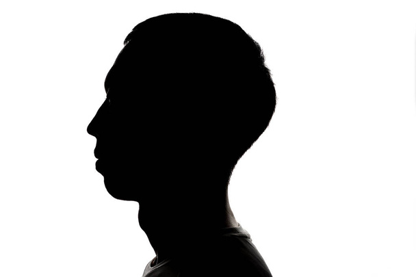Темный силуэт профиля молодого человека на белом фоне, понятие анонимности
 - Фото, изображение
